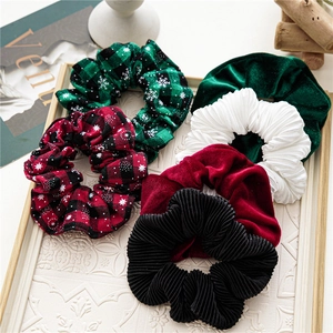 6-piece set of velvet and plaid Christmas hair scrunchies on a white decorative tray