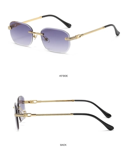 Detail view of purple gradient rimless sunglasses with gold metal frame and rhinestones
