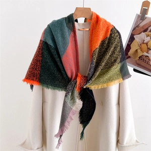 Macro detail of colorful plaid scarf with fringes on white coat