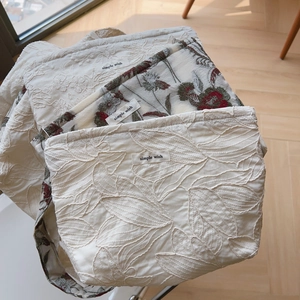 Detailed stack of cotton linen embroidered handbags with simple wish woven labels