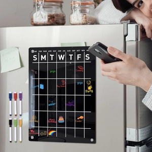 Close-up of magnetic acrylic weekly calendar board with colorful markers on a fridge