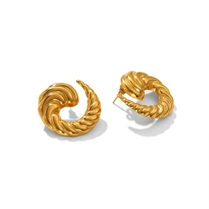 Détail macro de boucles d'oreilles spirales irrégulières dorées à texture torsadée