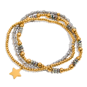 Minimalist stackable beaded bracelet set with a gold star pendant in a metallic finish
