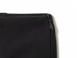 Close-up of black fabric texture with a seamless invisible zipper on the garment side