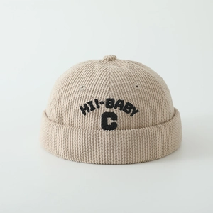 Détail du bonnet en velours côtelé beige avec broderie noire HI!-BABY et lettre C