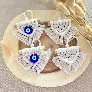 Set of four beige woven cotton evil eye wall hangings with tassels and wooden rods