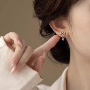 Detailed view of gold-plated cat stud earring with colorful zircon and snowflake pendant