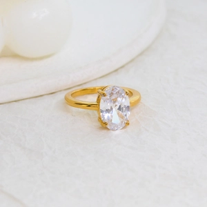 Detailed side view of an oval-cut clear zircon ring with a classic gold four-prong setting