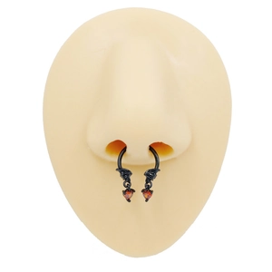 Close-up of black bat wing nose rings with orange heart charms on silicone model