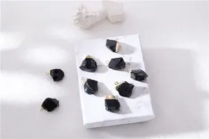 Artistic layout of eight natural obsidian raw stone pendants with gold-plated metal caps