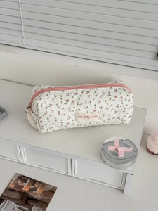Détail d'une trousse à maquillage matelassée à fleurs avec fermeture éclair de qualité