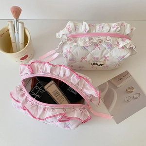 Quilted floral makeup bag with pink bow and ribbon lace trim on a white vanity