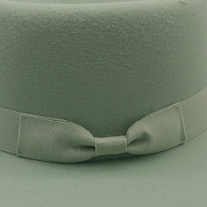 Détail du chapeau en feutre de laine vert avec ruban gros-grain et nœud assortis