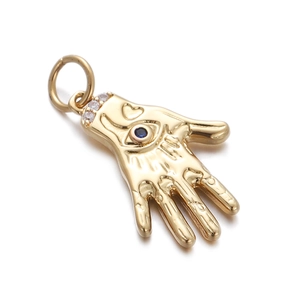 Macro detail of golden Hamsa pendant with blue evil eye stone and sparkling crystals
