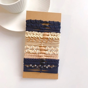 Detailed view of elastic hair ties set with beads and crystals on a kraft display card