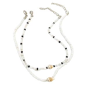 Détail de chaînes de perles blanches et noires avec breloques coquillages et fermoirs