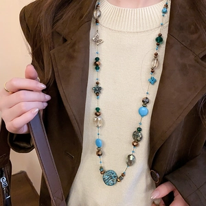 Detail of bohemian layered beaded necklace with butterfly pendant and turquoise accents