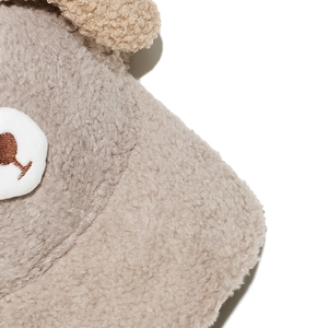 Detailed macro shot of soft plush faux fur texture with cute cartoon bear embroidery