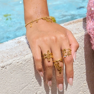 Gold music note ring and bracelet set for women shown at a summer poolside setting