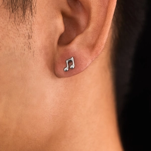 Minimalist silver music note stud earrings for men and women on ear model