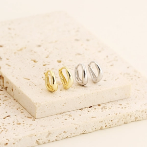 Detail showing S925 sterling silver stamp on minimalist gold and silver U-shaped earrings