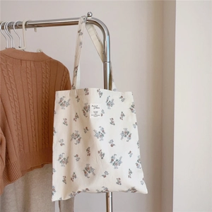 Détail d'un sac cabas en toile à fleurs vintage montrant les motifs et la texture du tissu