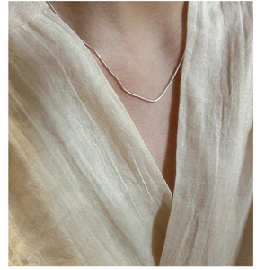 Dettaglio della collana a catena serpente in argento minimalista indossata da modella