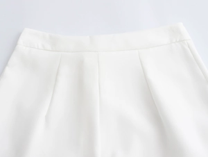 Detailed macro view of high-waist white woven trousers featuring precise dart tailoring
