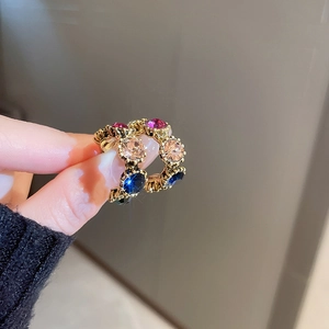 Macro detail of retro gold earrings with vibrant purple and blue round crystals