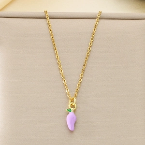 Gros plan d'un pendentif piment violet sur une chaîne dorée sur un support texturé