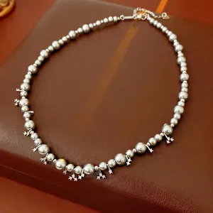 Silver-grey pearl necklace with zircon star pendants on a luxury leather jewelry box