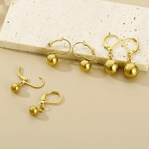 Detailed view of three sizes of high-polished gold oval hoop earrings with steel beads