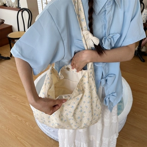 Close-up of small floral canvas tote bag showing side view and internal zip pocket detail