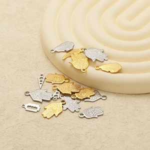 Detailed collection of gold and silver Hamsa hand, feather, and blade metal charms for DIY