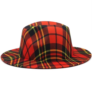 Close-up of red plaid fedora hat showing textured wool fabric and Scottish tartan pattern
