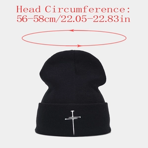 Detailed embroidery of a white cross on a black knit beanie with size info 56-58cm