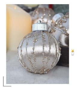 Close-up of 8cm silk Christmas ball with vertical gold sequins and festive silver loop