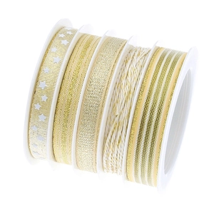 Detail of five rolls of gold and white Christmas ribbons with stars and stripes patterns
