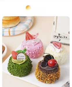 Macro view of realistic mousse cake models with faux coconut, matcha, and strawberry toppings