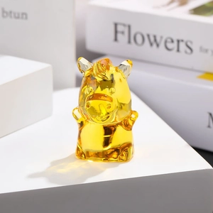 Detail shot of a yellow crystal pig zodiac ornament on a minimalist home desk setup