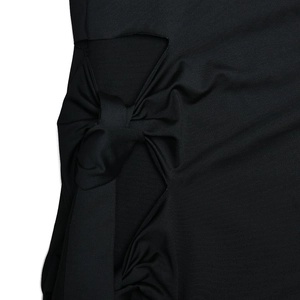 Détail de la robe noire élégante avec un nœud papillon stylé et une découpe moderne