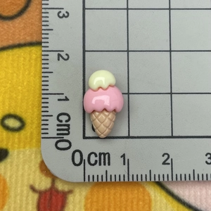 Macro shot of a 2cm resin ice cream charm on a measuring grid for DIY craft scaling