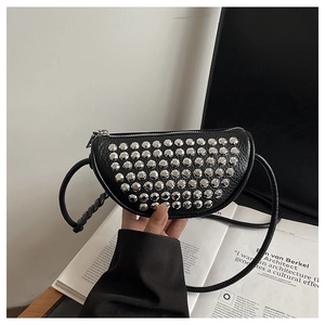 Close-up of black lychee grain leather crossbody bag with silver rivet details