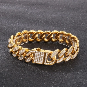 Hip hop gold plated Cuban link bracelet with iced out pavé rhinestones on stone background