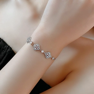 Detailed view of silver flower bracelet with sparkling white zircons on female wrist
