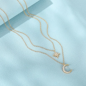 Detailed macro view of layered gold star and crescent moon pendants with pavé crystals