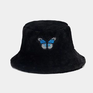 Detailed view of black plush bucket hat featuring a blue butterfly embroidery patch