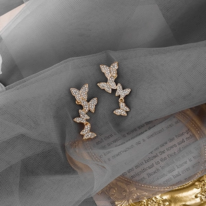 Detailed macro view of cascading gold butterfly earrings with brilliant white zircons