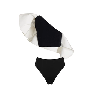 Detail of black one-shoulder swimsuit with tiered white ruffles and high waist bottom