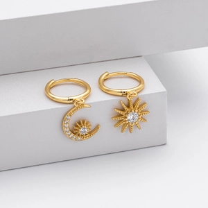 Detail of gold asymmetric S925 earrings with sparkling crescent moon and star charms